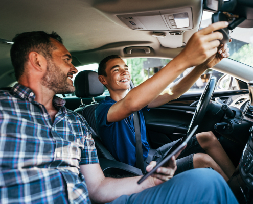Driving instructor sitting his student and explain to him car driving basics, how to properly prepare himself for a drive. View from inside.